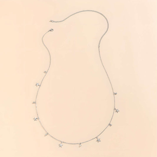 The Delicate Silver Stars Waist Chain Necklace features small star and teardrop charms on an adjustable silver chain, displayed on a light beige background. Ideal for styling with crop tops or your favorite bikini.