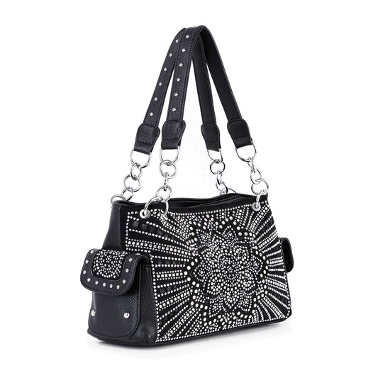 The Boho Bling Design Fashion Handbag features black faux leather, silver-tone hardware, and bold white/silver studded floral and sunburst accents. Dual studded handles and a side flap pocket add extra boho flair.