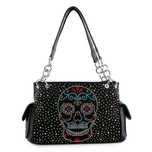 The Sugar Skull Fashion Handbag is a black faux leather shoulder bag with silver studs, a colorful rhinestone sugar skull on the front, twin handles, and convenient side pockets.