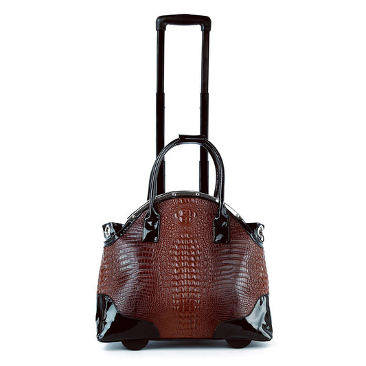 The Wheeled Carry On Fashion Luggage features a brown crocodile-patterned design with black patent faux leather accents, two handles, an extended telescopic handle, and stands upright on two wheels.
