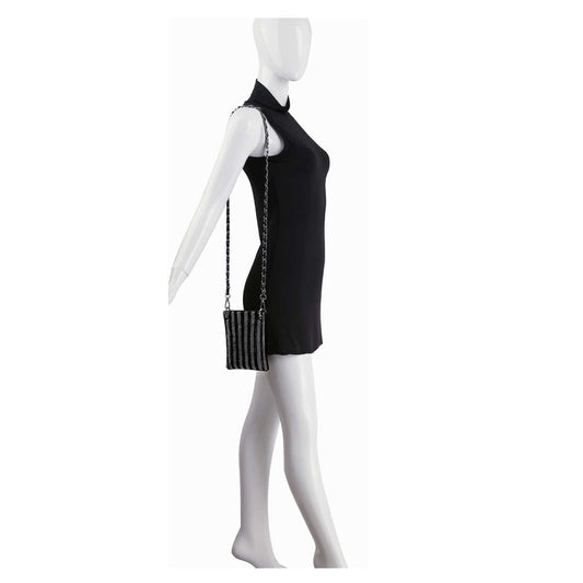 A mannequin in a sleeveless black dress holds the Striped Rhinestone Petite Crossbody Sling, a small sparkling bag with black and silver stripes and a chain strap, set against a plain white background for a glamorous finishing touch.