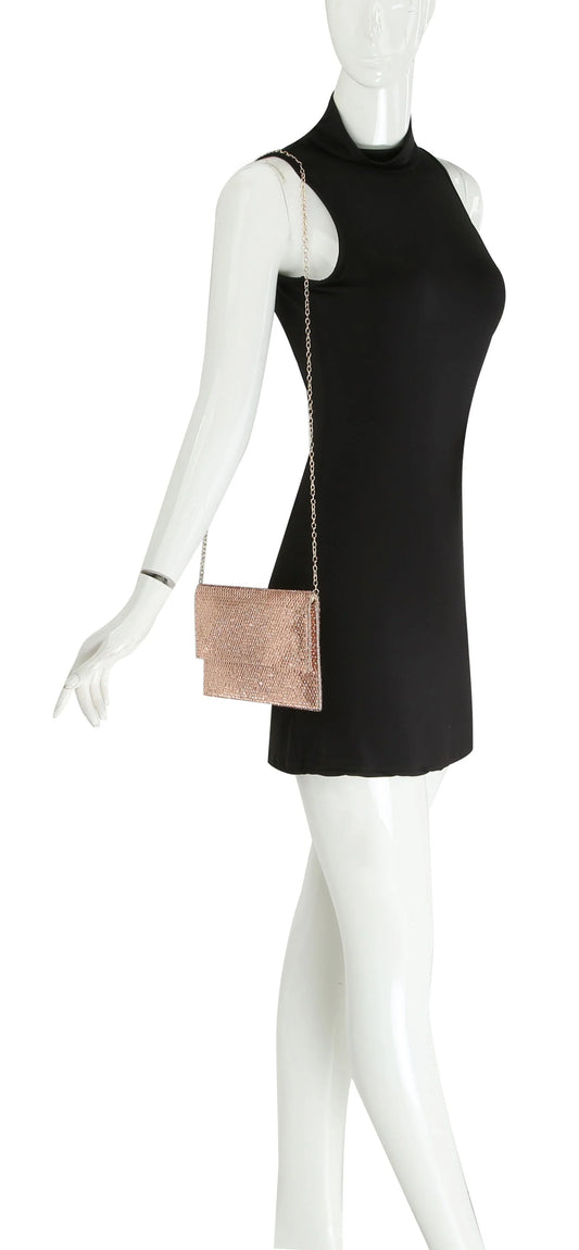 A mannequin in a sleeveless black mini dress displays the Colored Stone Style Evening Bag, featuring a rose gold chain strap and top flap closure, hanging from its shoulder.