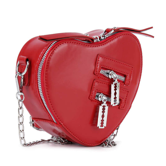 The Modern Heart Petite Shoulder Bag is a red, heart-shaped faux leather purse with shiny silver zippers, three decorative front zippers, a chain strap, and curved edge stitching for extra style.