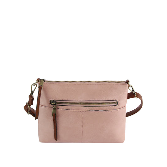 The Front Pocket Slim Crossbody Bag, in light pink faux leather, features a front zip pocket, top zip closure, and adjustable brown shoulder strap. Shown against a plain white background.