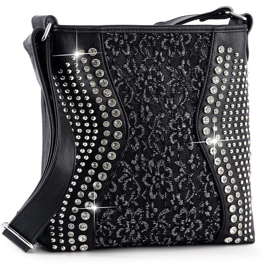 The Brilliant Rhinestone and Lace Crossbody Sling is a black faux leather handbag with silver studs, sparkling rhinestones, a central floral lace pattern, and a glossy black strap.