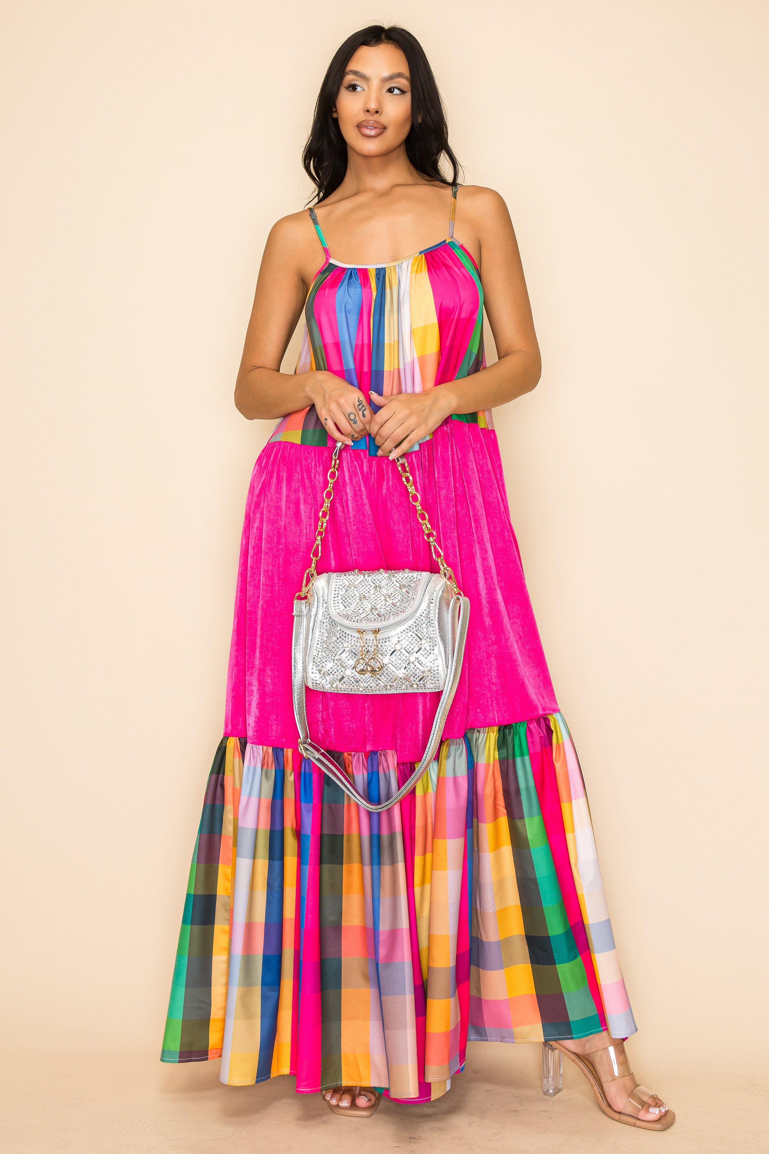 Woman in a colorful, sleeveless plaid maxi dress with bright pink sections holds a Rhinestone Design Top Flap Petite Handbag and wears clear-heeled shoes, standing against a beige background.