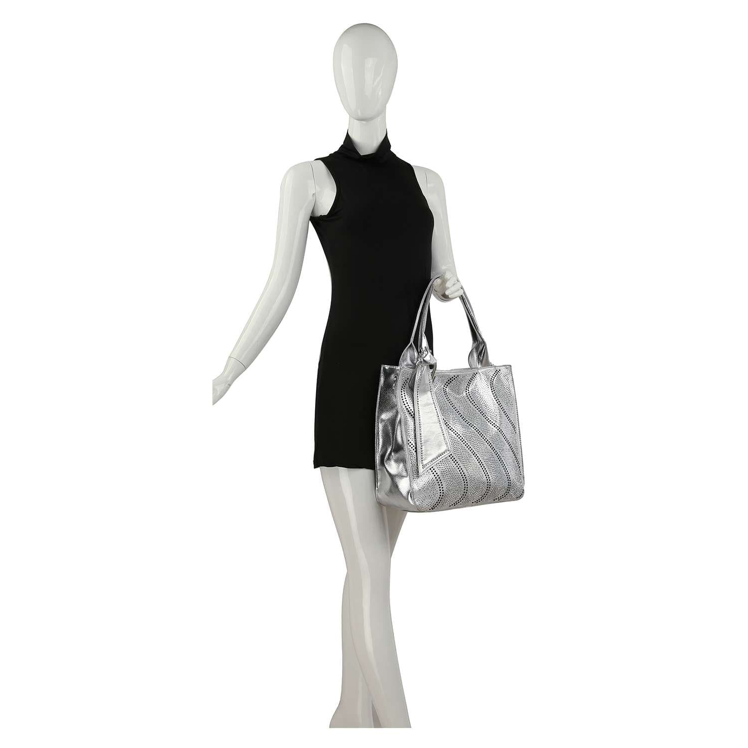 A white mannequin in a sleeveless black mini dress holds a Rhinestone Pattern Tote, a large silver bag with tablet compatibility and wave designs, against a plain white background.