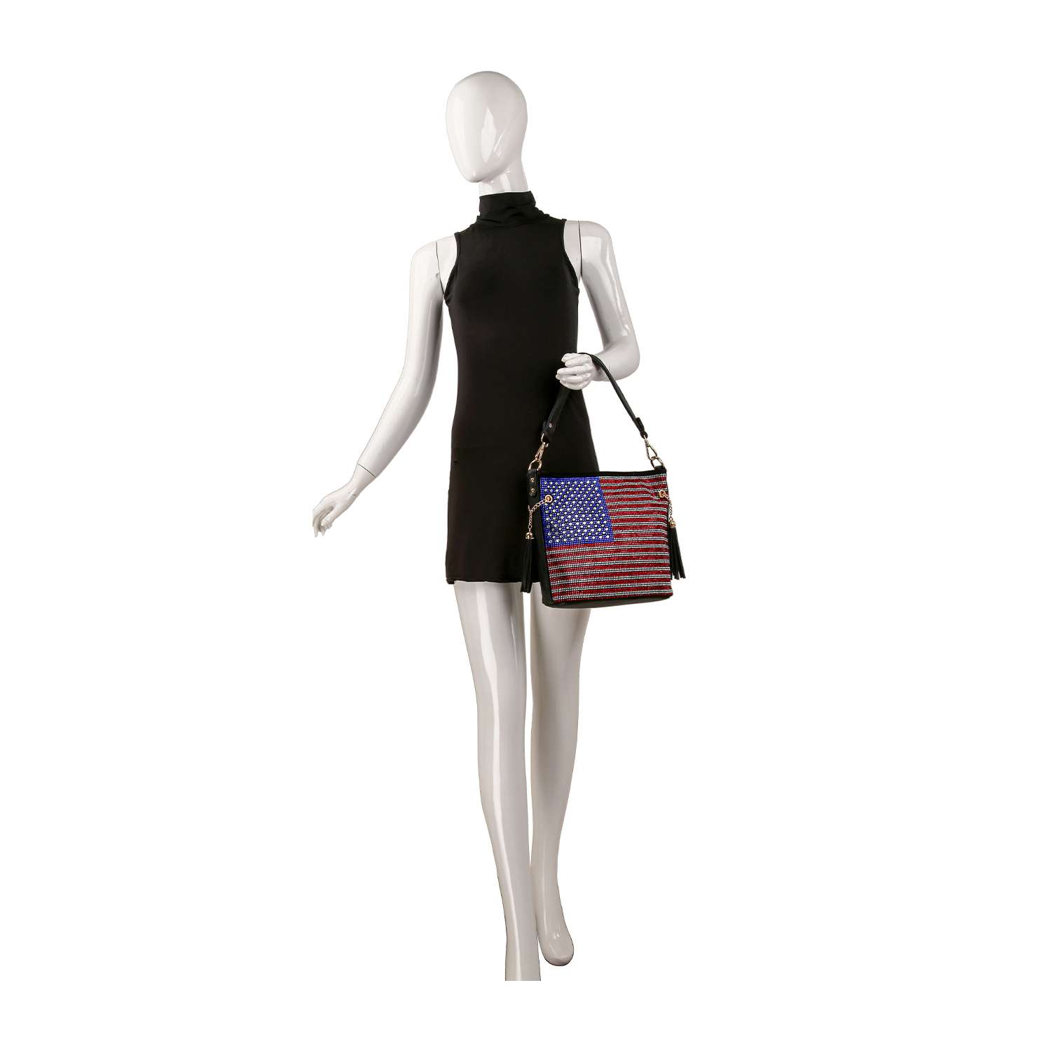 A mannequin in a sleeveless black dress holds the Rhinestone Flag Americana Hobo Crossbody, an everyday bag featuring an American flag design, against a white background.