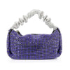 The Ruched Sparkling Stone Fashion Bag is a petite rectangular handbag adorned with shiny purple and silver rhinestones, featuring a ruched silver handle and top zipper—ideal for adding glamour to any outfit.