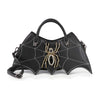 The Bat Wing Rhinestone Spider Accent Fashion Bag is a black faux leather handbag with white web stitching, a gold and rhinestone spider centerpiece, and a detachable shoulder strap.