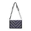 The Ultra Petite Sparkling Shoulder Bag is a rectangular black faux leather purse featuring a silver beaded chain strap, black strap, and front chevron-patterned silver and blue studs.