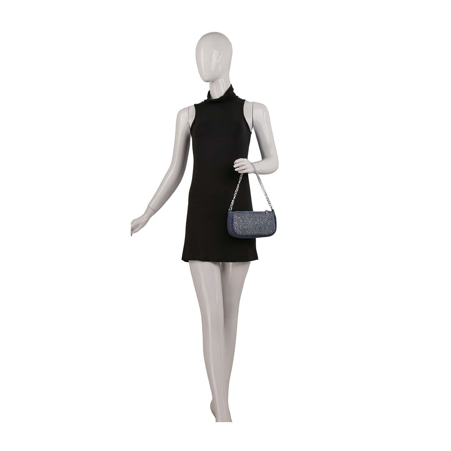 A mannequin in a sleeveless black mini dress holds the Denim Bling Shoulder Bag—a chic blue denim accessory with a chain strap—on its right arm, posed against a plain white background.