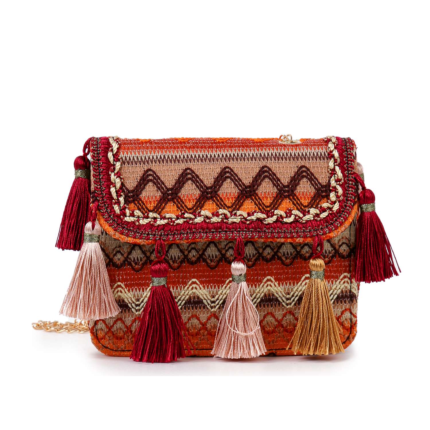 The Tassel Accented Woven Design Shoulder Bag features a colorful boho zigzag pattern in red, orange, and beige with tasseled accents in red, beige, and brown, plus a gold shoulder chain.
