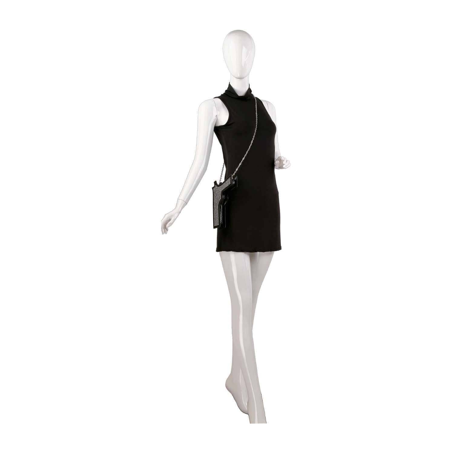 A white mannequin poses with one arm bent and one leg forward, wearing a sleeveless black mini dress and carrying the Rhinestone Pistol Design Evening Bag, featuring chic faux leather and a chain strap, set against a white background.
