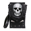 The Skull Design Cell Phone Holder Crossbody is a small faux leather bag with a textured flap, large embroidered silver skull, and metal studs. This edgy micro crossbody has a detachable strap for versatile styling.