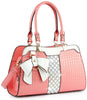 The Brilliant Bow Sparkling Hand Tote is a stylish pink faux leather handbag featuring embossed croc texture, dual handles, a large white bow, gold hardware, and a central white and gray checkered accent panel.