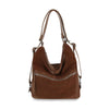 The Genuine Leather Convertible Hobo Backpack features brown suede, a slouchy shape, silver zippers, adjustable straps for shoulder or crossbody wear, a front zip pocket, and a soft design for a stylish backpack purse look.