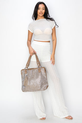 A woman poses against a white background wearing a sheer, white crop top and matching pants, holding the Sparkling Rhinestone Shoulder Bag with brown handles and tassel detail.