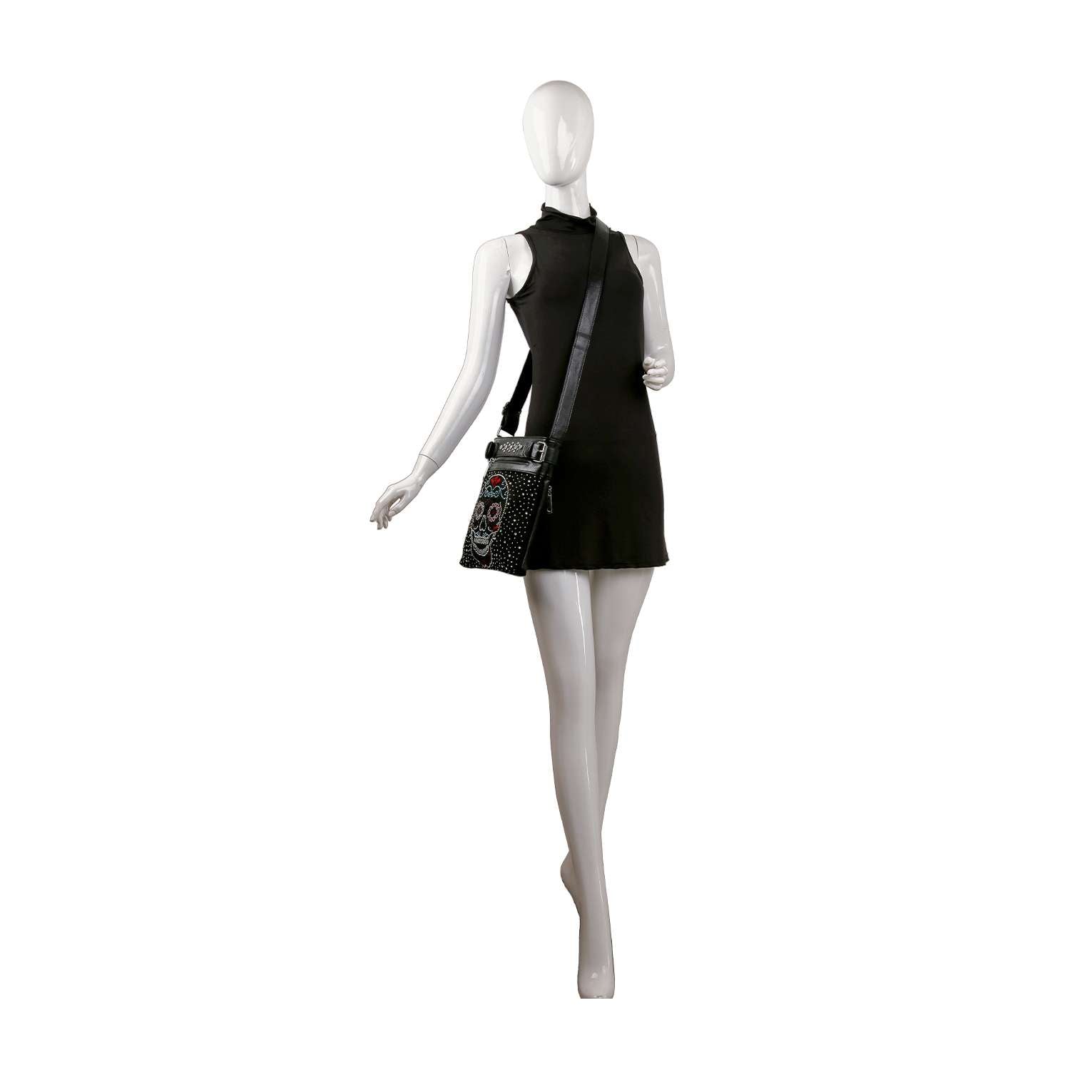 A white mannequin wears a sleeveless black mini dress and carries the Sugar Skull Rhinestone Crossbody Sling with an ornate multicolor Dia de los Muertos design, standing against a plain white background.