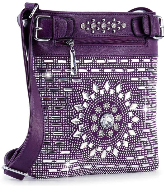 The Brilliant Rhinestone Crossbody Sling is a purple faux leather bag with silver rhinestones in geometric patterns, a central circular sparkling accent, adjustable strap, and zippered top closure.