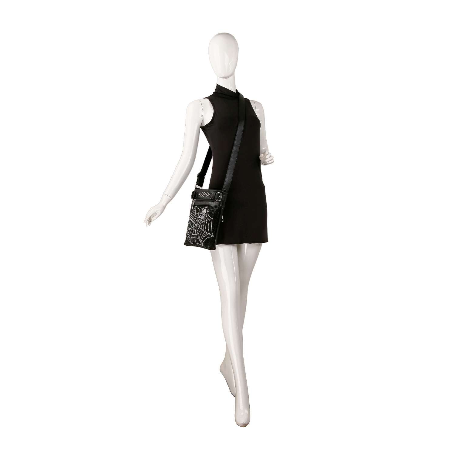 A mannequin models a sleeveless black mini dress and the Rhinestone Spider Web Crossbody Sling, featuring a white spiderweb design, against a plain white background.