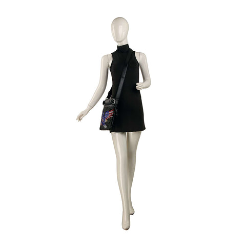 A mannequin in a sleeveless black mini dress carries the Patriotic Eagle Bling Crossbody Bag, featuring a colorful design, posed as if walking against a white background.