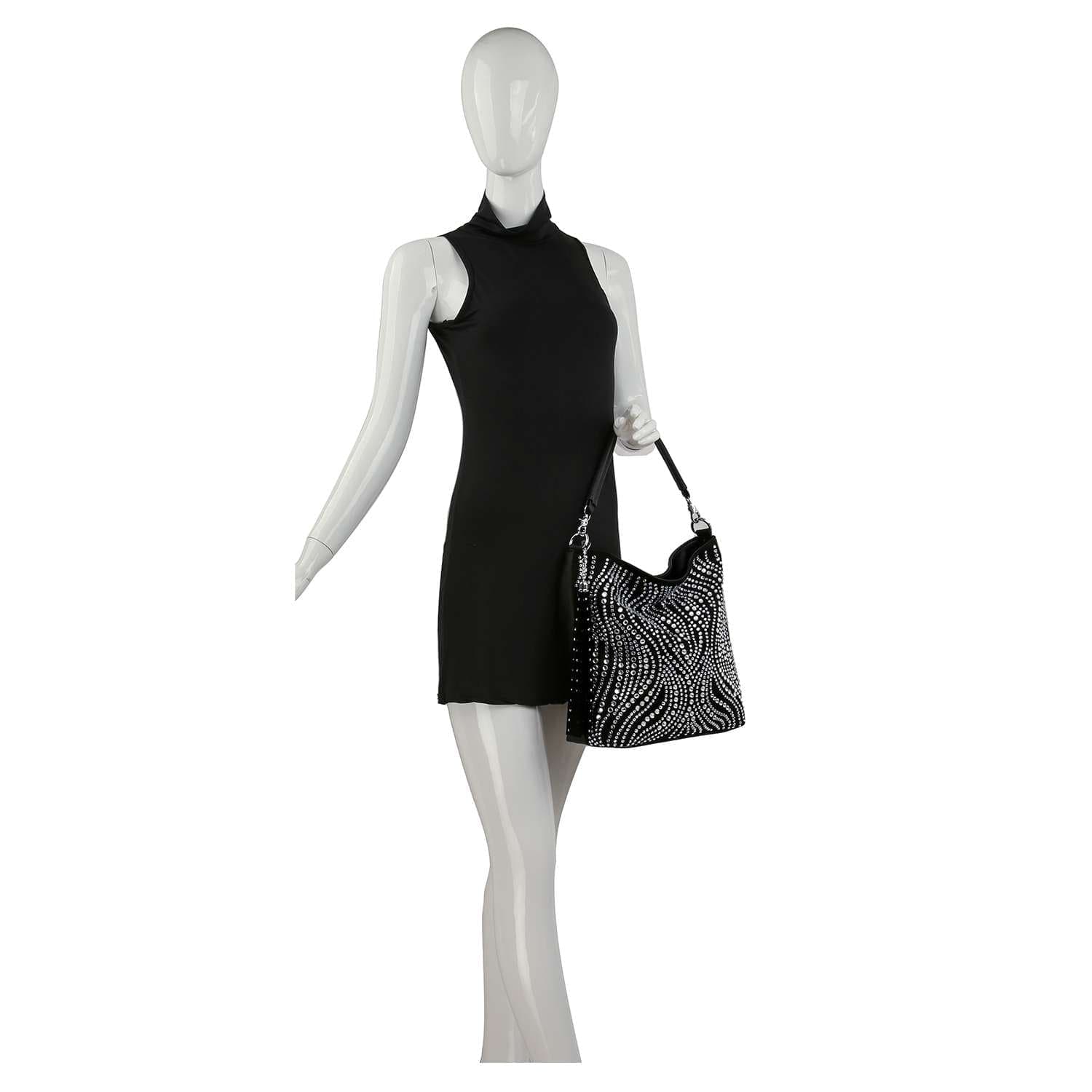 A mannequin in a sleeveless black mini dress holds the Stunning Stone Hobo Handbag, a chic faux leather accessory featuring white studded swirl patterns. The background is plain white.