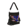 The Patriotic Eagle Hobo Crossbody Bag is a black faux leather bag with silver studs, a rhinestone eagle with outstretched wings, detachable strap, silver hardware, and two black tassels on the sides.