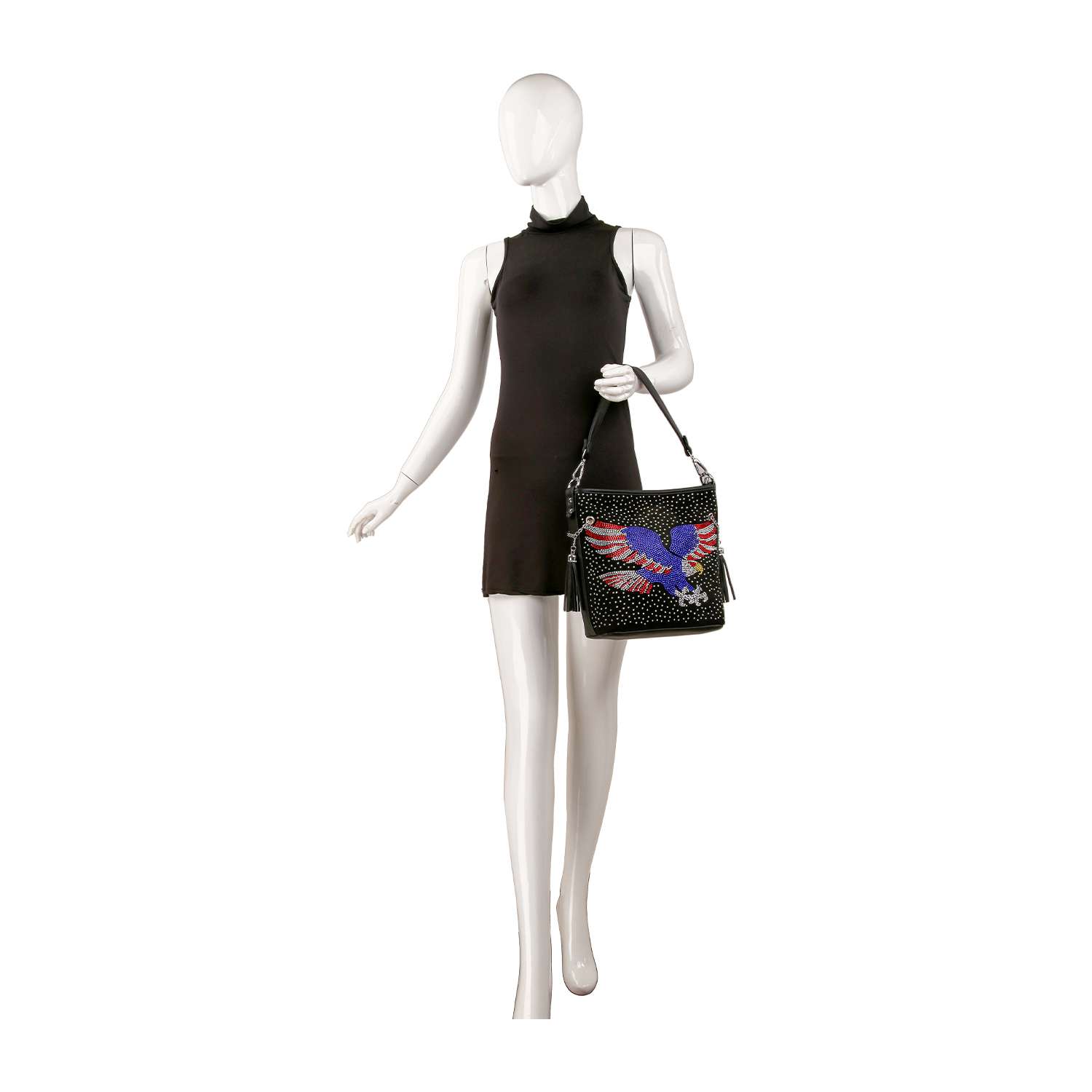 A mannequin in a sleeveless black dress holds the Patriotic Eagle Hobo Crossbody Bag, featuring colorful bird embroidery, silver studs, and rhinestone eagle detail against a white background.