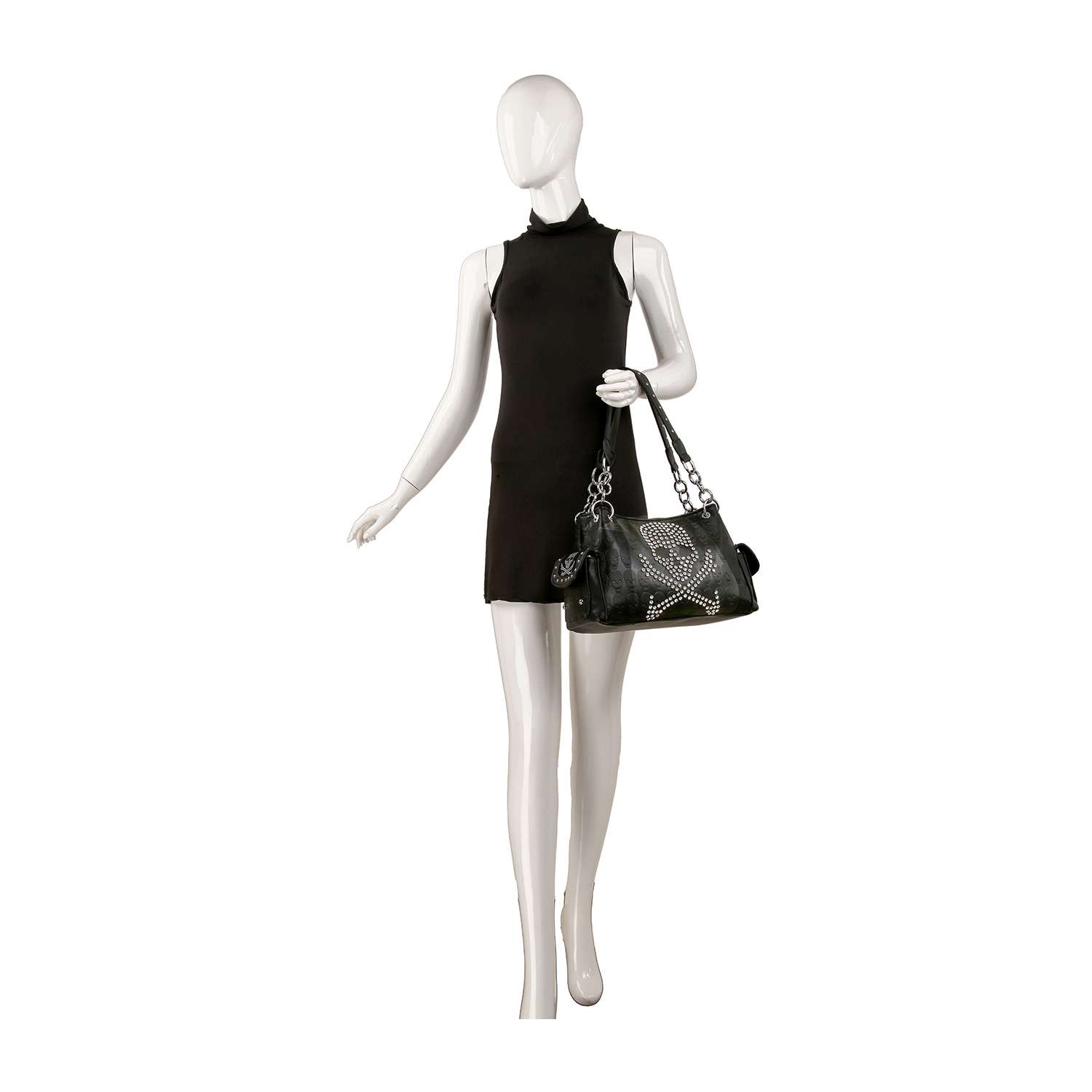 A white mannequin in a sleeveless black dress holds the Skull And Crossbones Embossed Fashion Handbag, featuring silver chain straps and rhinestone details, posed against a plain white background.