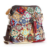 The Genuine Leather Multi Color Floral Shoulder Bag features multicolor leather flowers, gold hardware, a red tassel zipper pull, and comes with a detachable dark strap for versatile styling.