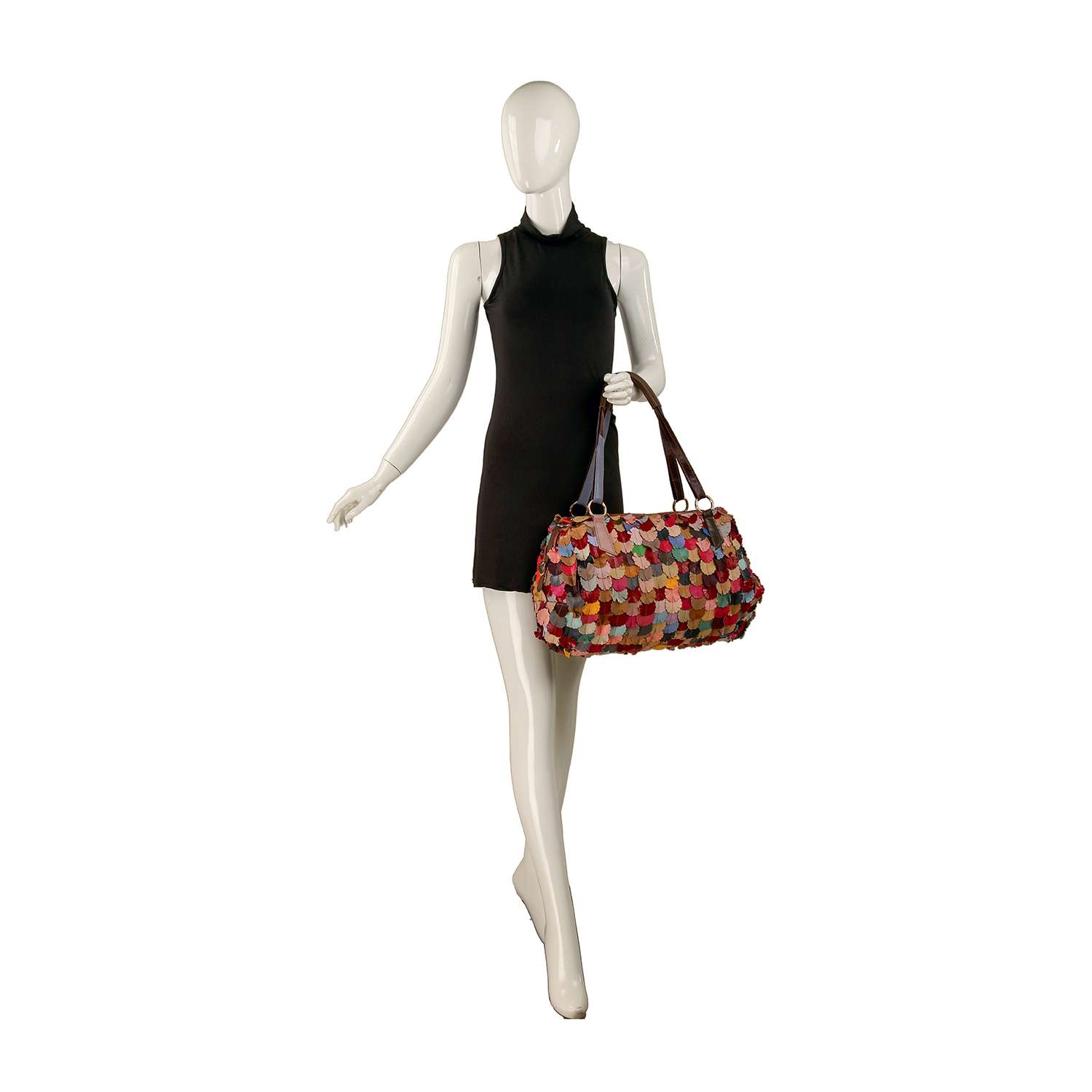 A mannequin in a sleeveless black dress holds the Genuine Leather Colorful Petal Weekender Bag, a large tote with multicolored circular patches and brown handles, standing against a white background.