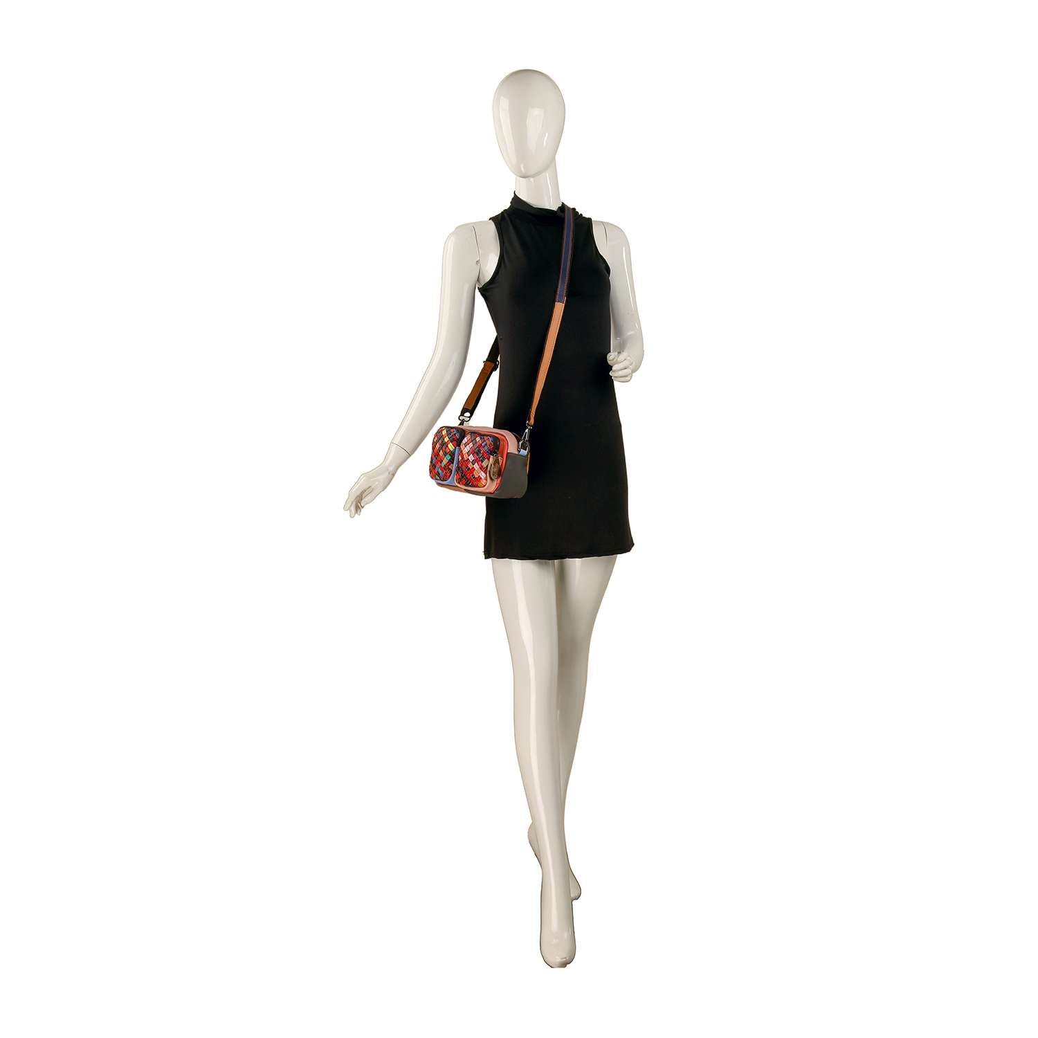 A white mannequin in a sleeveless black dress poses with the Genuine Leather Woven Front Pocket Crossbody Sling, featuring a floral pattern, multiple pockets, and a tan leather strap against a plain white background.