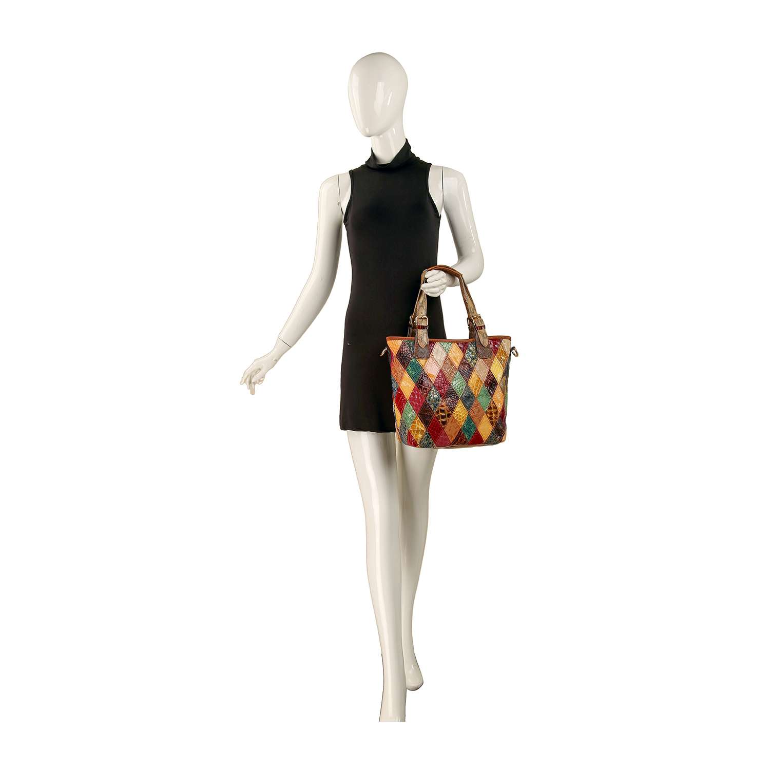 A mannequin in a sleeveless black dress holds the Genuine Leather Tall Patchwork Tote, an oversized bag with brown handles and a lively diamond pattern, handcrafted to stand out against the white background.