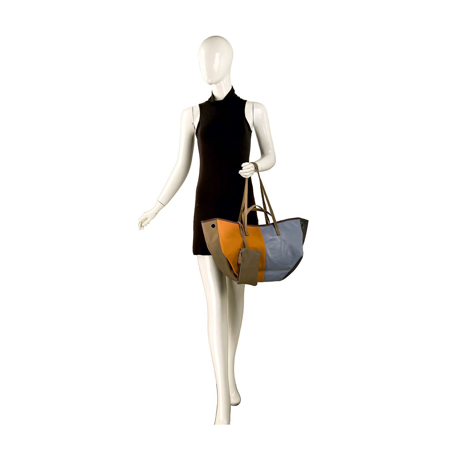 A mannequin in a sleeveless black dress holds the Genuine Leather Color Block Large Shoulder Bag, featuring tan, mustard yellow, light blue, and gray panels. The mannequin is posed as if walking with this stylish accessory.
