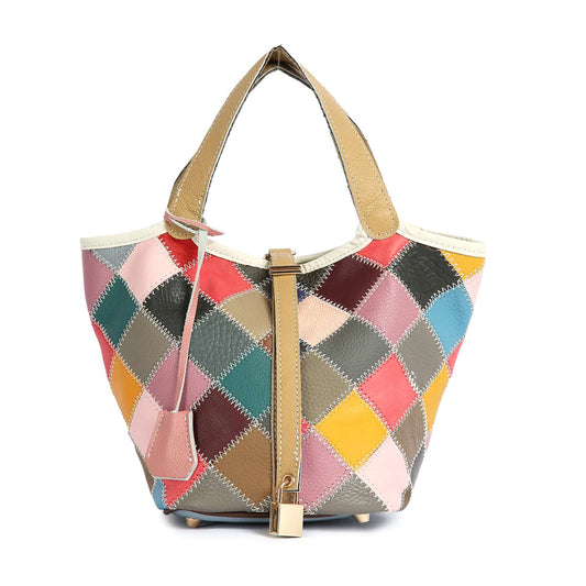 The Genuine Leather Colorful Patchwork Tote features two tan handles, a diamond-shaped patchwork in pink, blue, brown, yellow, and red, a front tan strap with a lock detail, and refined top stitch accents.