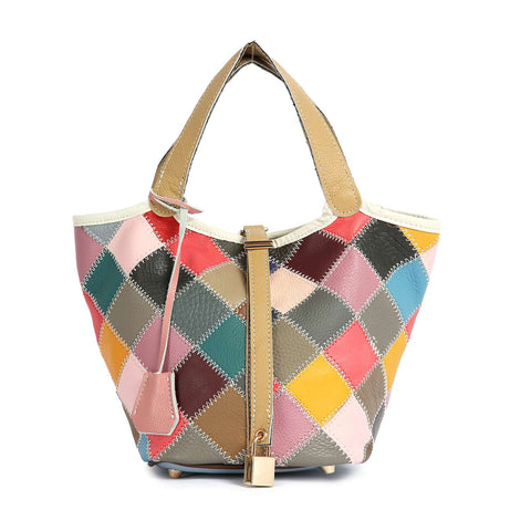 The Genuine Leather Colorful Patchwork Tote features two tan handles, a diamond-shaped patchwork in pink, blue, brown, yellow, and red, a front tan strap with a lock detail, and refined top stitch accents.
