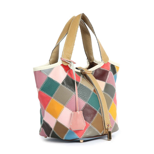 The Genuine Leather Colorful Patchwork Tote features tan handles, colorful diamond-shaped patchwork, top stitch detailing in pink, yellow, blue, green, and brown shades, a zipper closure, and a small hanging tag.