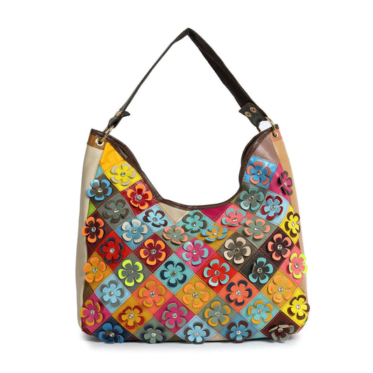 The Genuine Leather Raised Flower Shoulder Bag is a large, handcrafted, multicolored bag with square patchwork panels, each adorned with vibrant layered flower designs in red, yellow, blue, orange, and green.