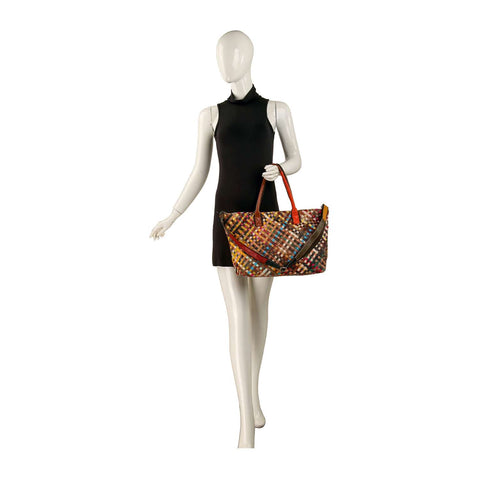 A mannequin in a sleeveless black dress holds the Genuine Leather Woven Large Tote Handbag, featuring orange double handles and gold-toned hardware, against a plain white background.