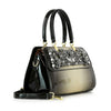 The Sparkling Patent Decorative Hand Tote features a black and gold gradient, shiny handles, detachable shoulder strap, and decorative gemstones on the front flap, all crafted from sleek patent faux leather.