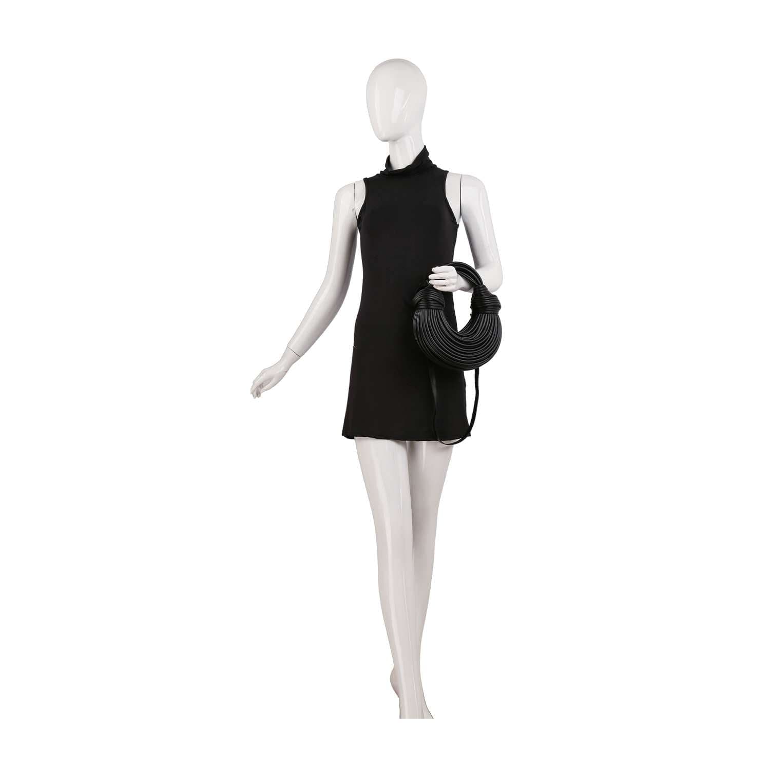 A white mannequin in a sleeveless black dress holds the Unique Hobo Handbag—a round, faux leather bag with a detachable strap—in its left hand, posed against a plain white background.