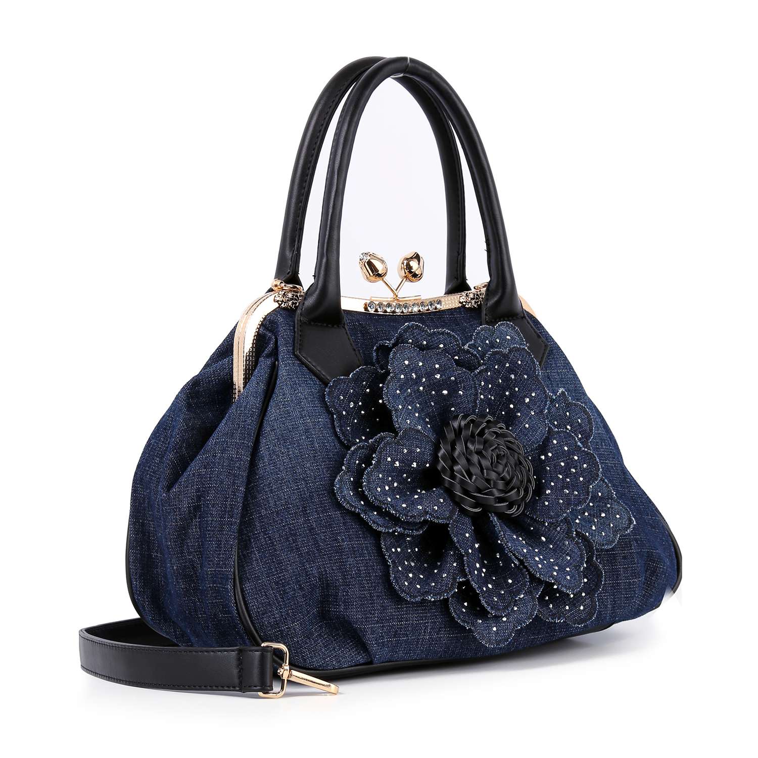 The Raised Flower Metal Frame Hand Tote is a dark blue denim handbag with black handles, gold hardware, a large decorative denim flower accented with white studs on the front, and a detachable black side strap for vintage-chic style.