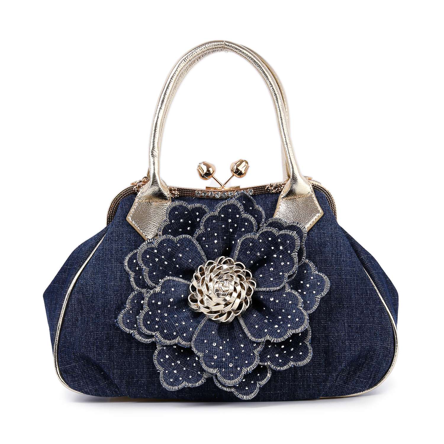The Raised Flower Metal Frame Hand Tote is a dark blue denim handbag with metallic gold handles, featuring a large layered fabric flower adorned with rhinestones and a silver brooch at its center.