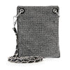 The Rhinestone Bling Petite Crossbody Sling is a black faux leather bag adorned with shiny silver studs, featuring a chain and leather threaded strap and metal grommets at the top corners.