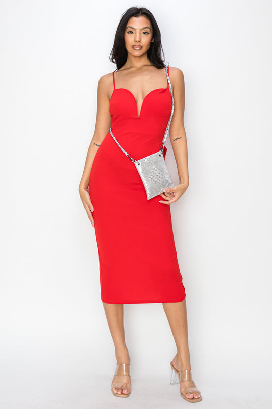 A woman stands against a white background wearing a form-fitting red dress, clear high heels, and the Diamond Design Petite Crossbody Sling.