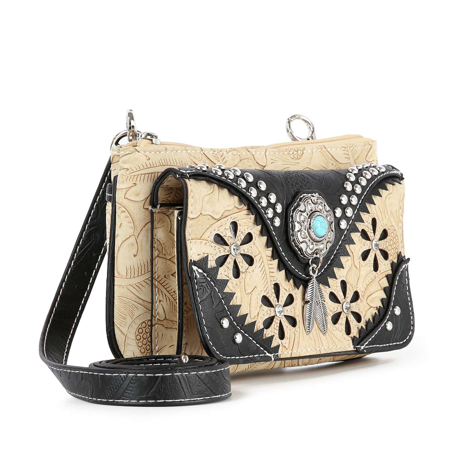 The Western Design Petite Crossbody Sling features beige and black faux leather, floral cutouts, silver studs, a turquoise accent, black strap, embossed patterns, and a decorative concho—combining western style with everyday practicality.