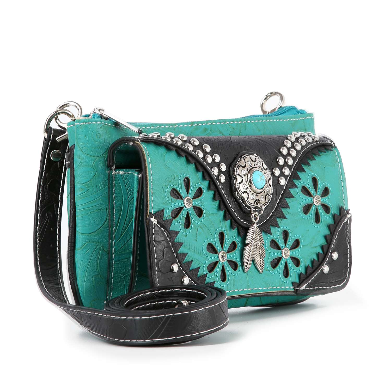 The Western Design Petite Crossbody Sling features turquoise and black faux leather with floral cutouts, silver studs, a decorative concho with turquoise stone, and a feather charm—combining western style and functionality.