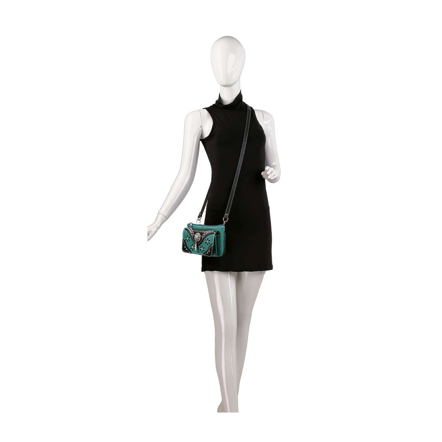 Mannequin wearing a sleeveless black dress and carrying the Western Design Petite Crossbody Sling, a turquoise faux leather bag with butterfly embroidery, perfect for use as a tablet-compatible crossbody.