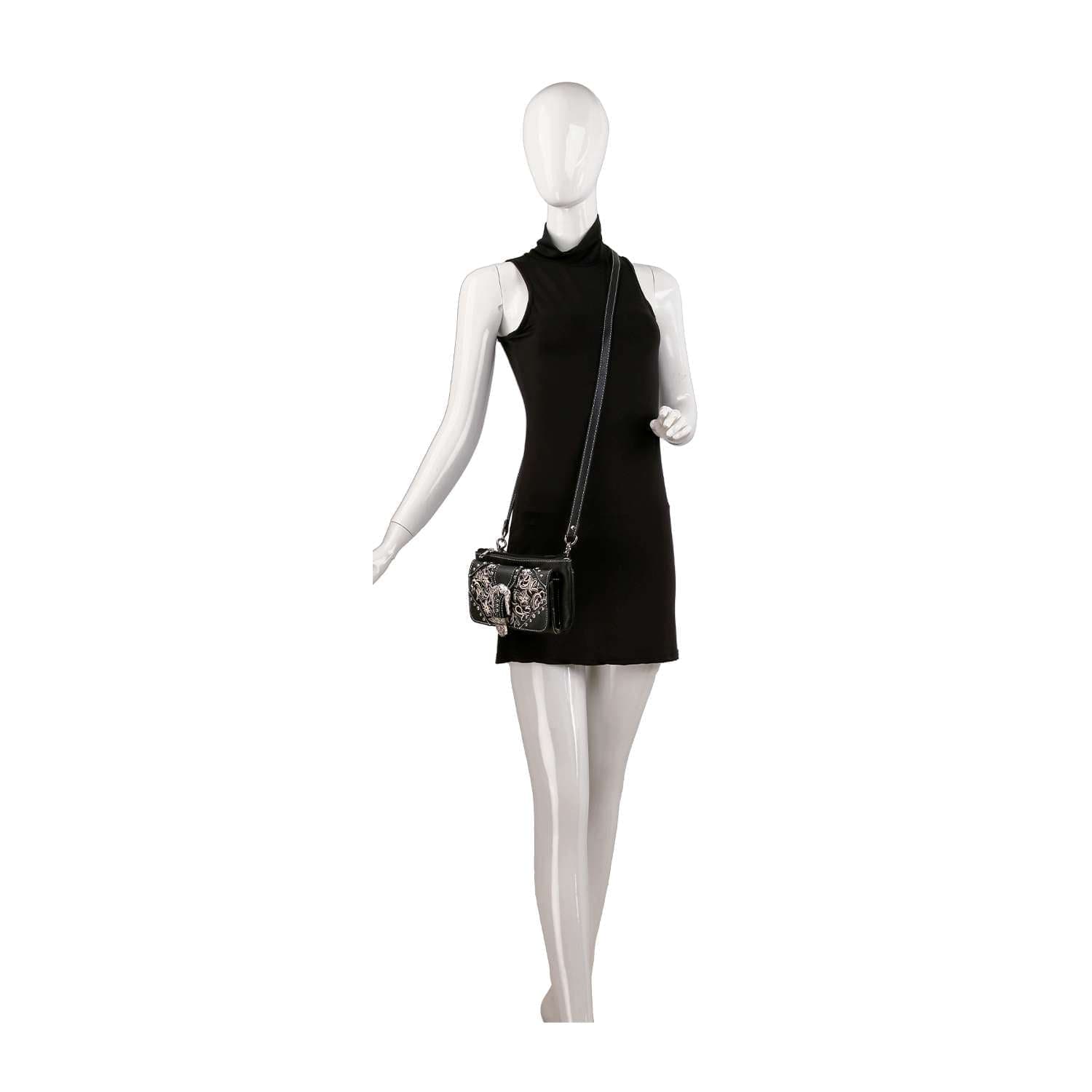 A white mannequin in a sleeveless black mini dress poses with the Western Buckle Design Petite Crossbody Sling, displayed against a plain white background.